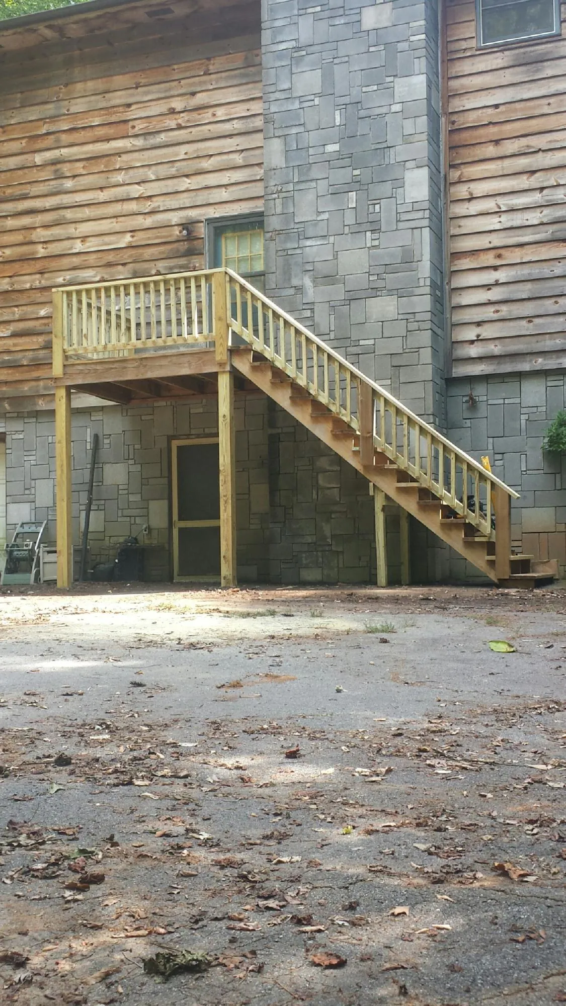 New pressure treated deck and stair landing on a log home in Sheridan